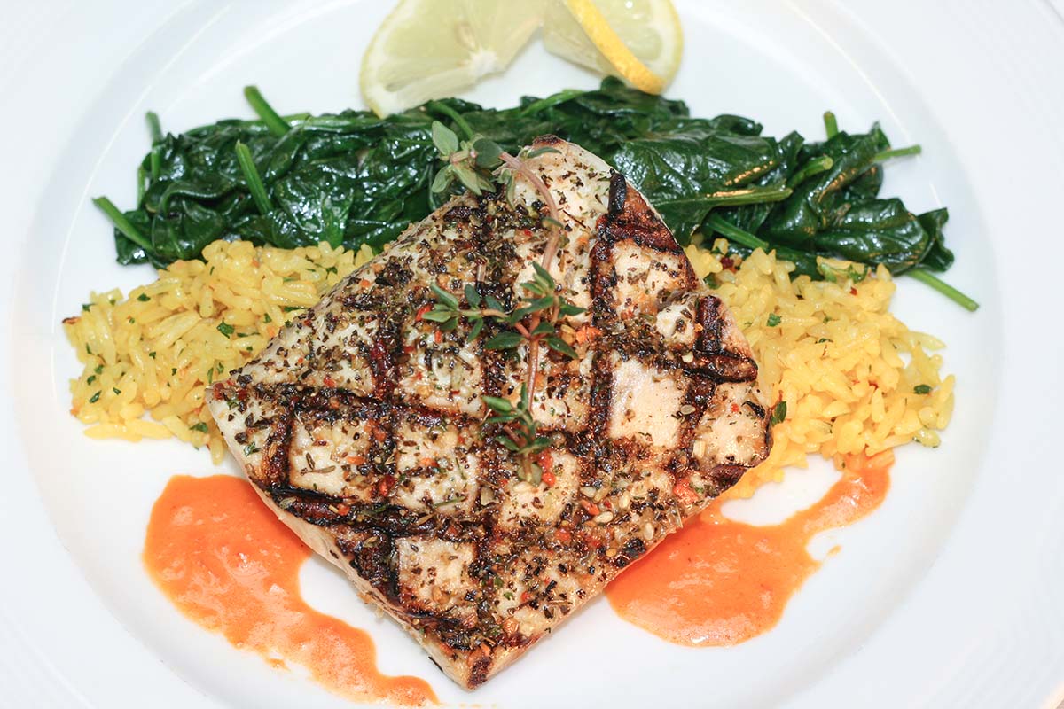 grilled wahoo with yellow rice, sauteed spinach, and lemon. 