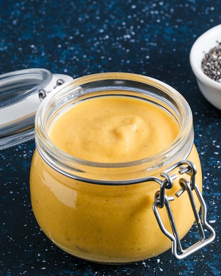 yellow creamy cashew sauce in a glass jar.