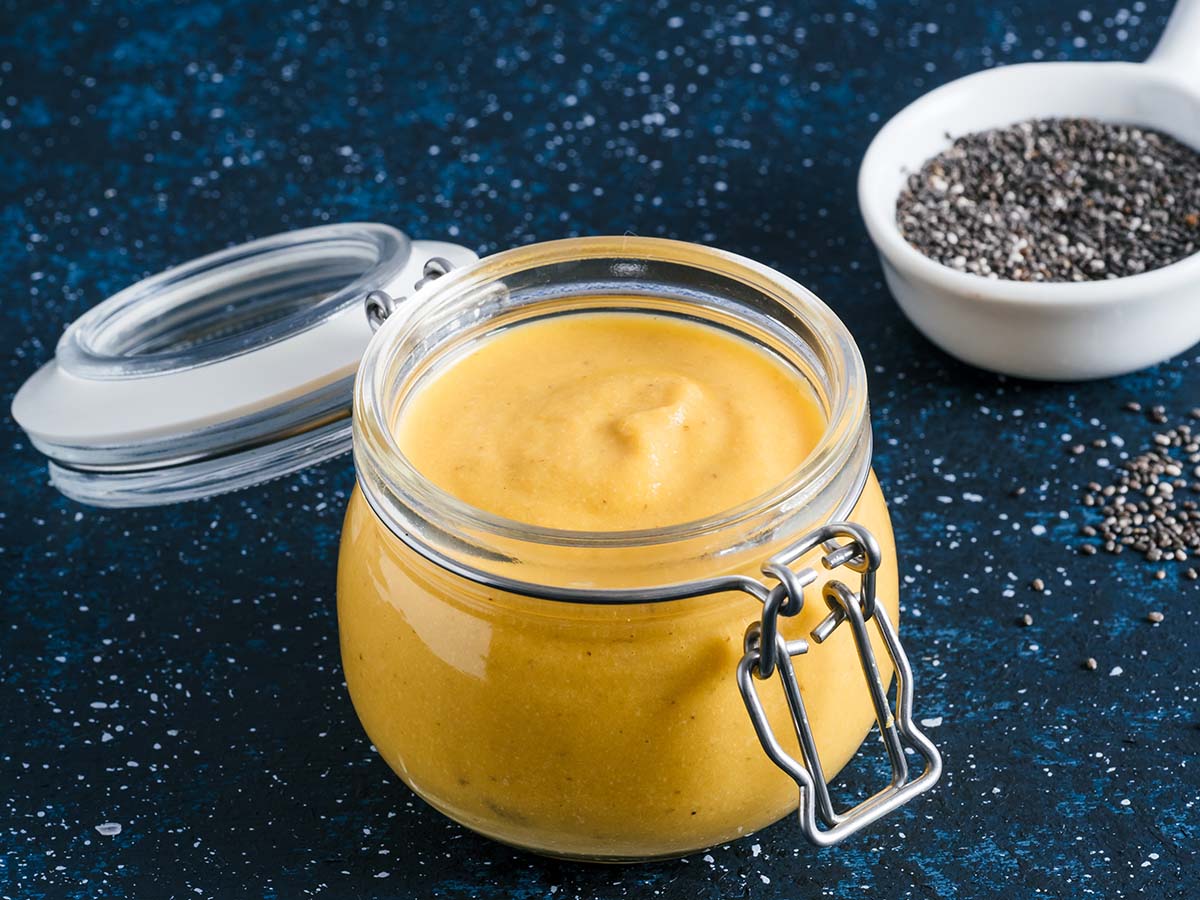 yellow creamy cashew sauce in a glass jar.