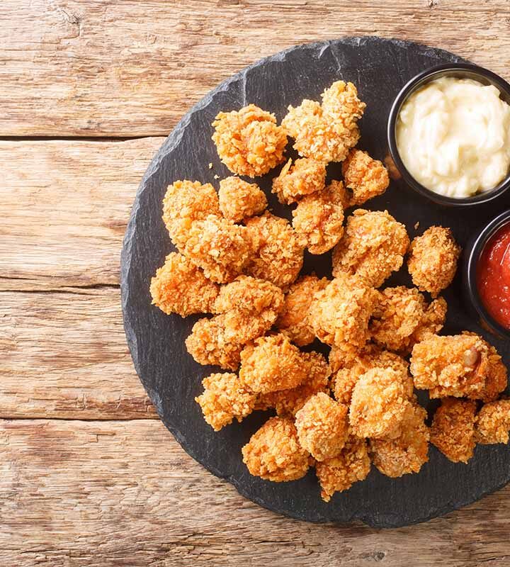 crispy alligator bites on a plate with ketchup on the side.