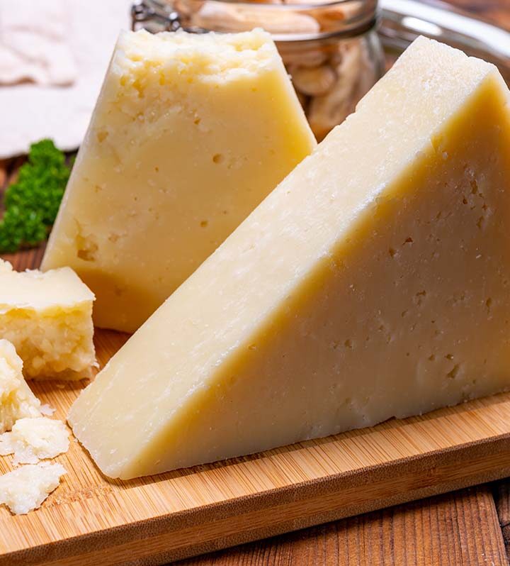 a block of romano cheese on a wooden board.