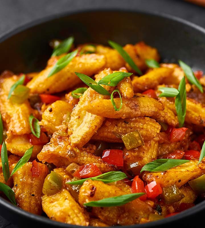 baby corn in a bowl with scallions and peppers.