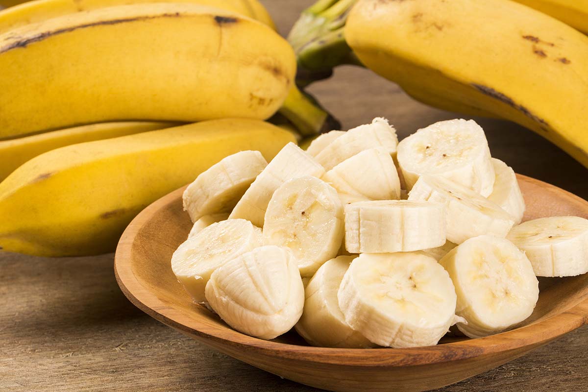 Sliced up bananas in a wooden bowl. 