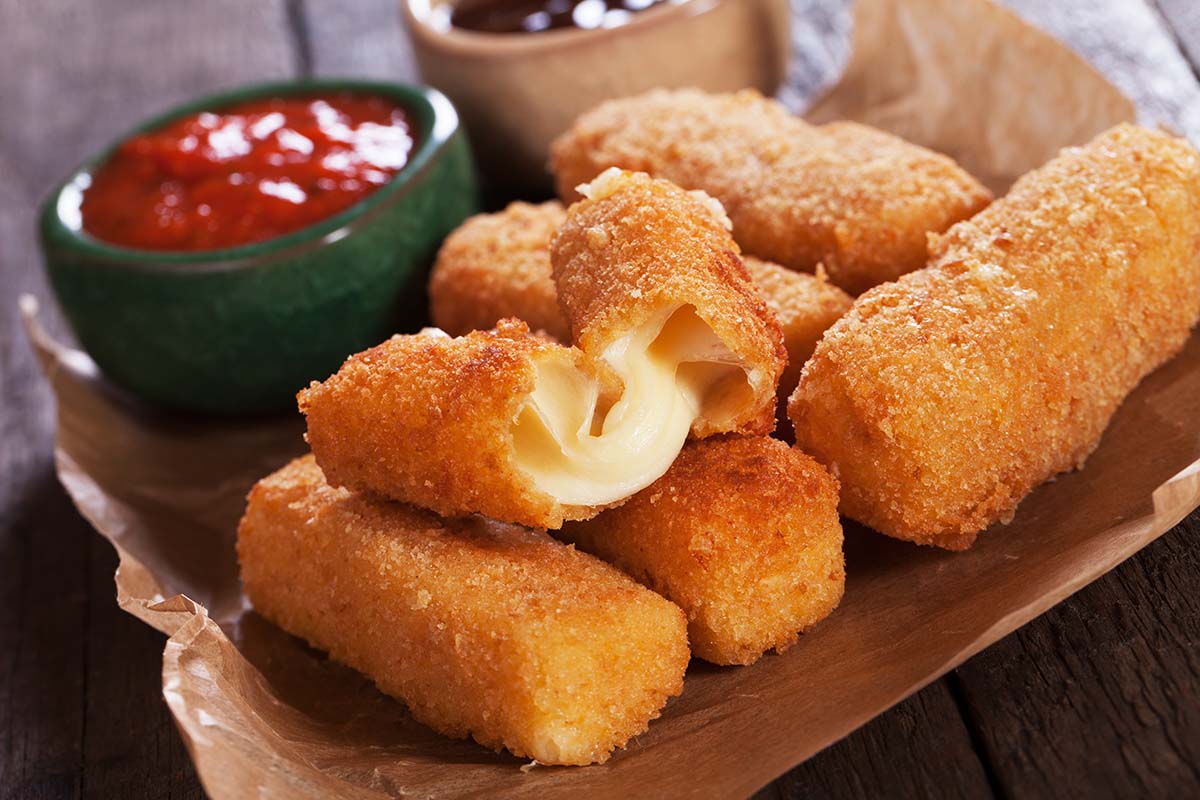 mozzarella sticks with marinara sauce on the side.